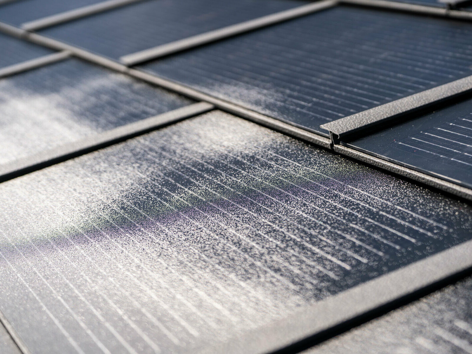 Gros plan sur la tuile solaire PREFA petit format, posée et du R.16 couleur P.10 gris sombre