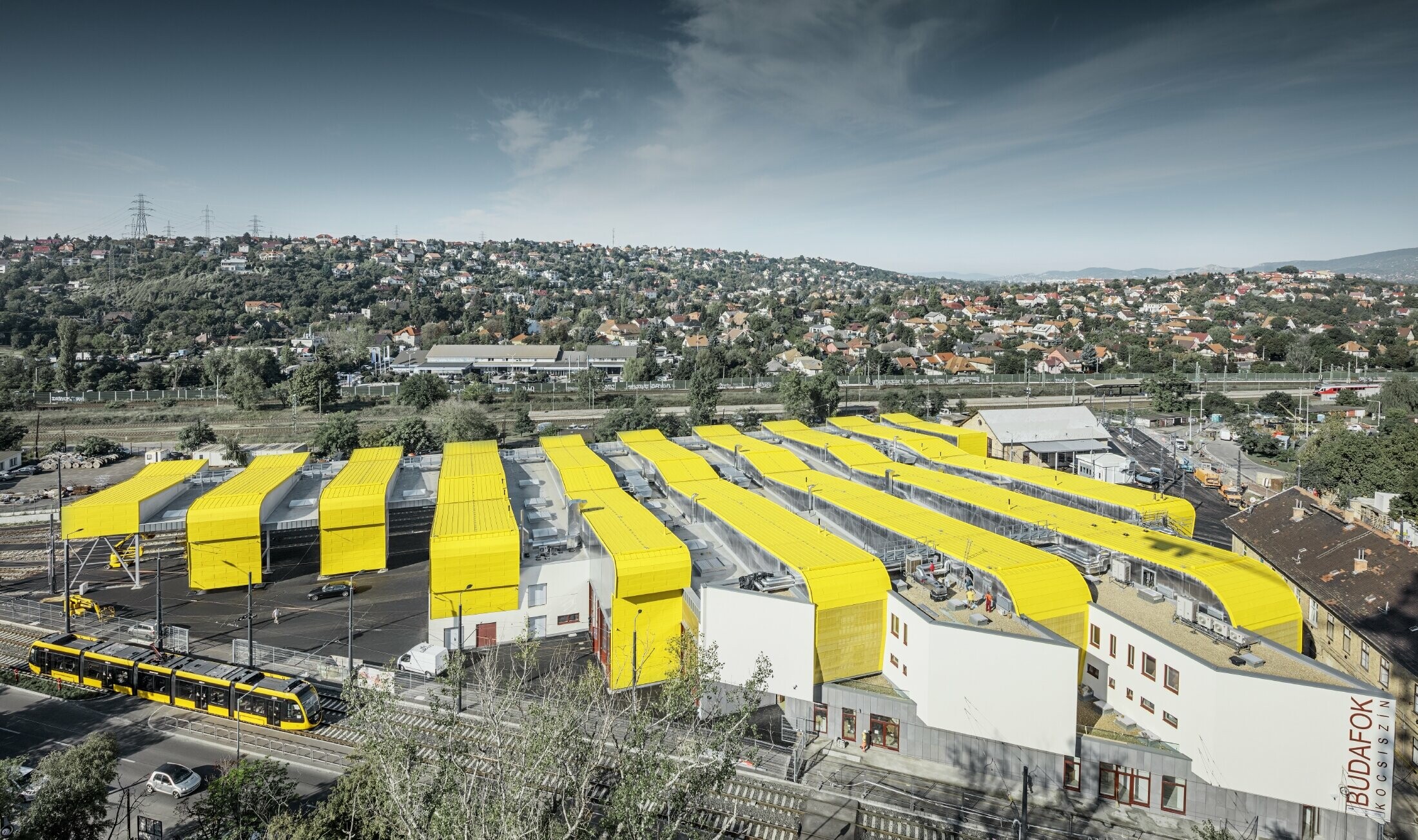 Vue aérienne de l’entrepôt à Budapest ; les bâtiments sont habillés de Prefalz PREFA au revêtement spécial jaune signalisation, RAL 1023.