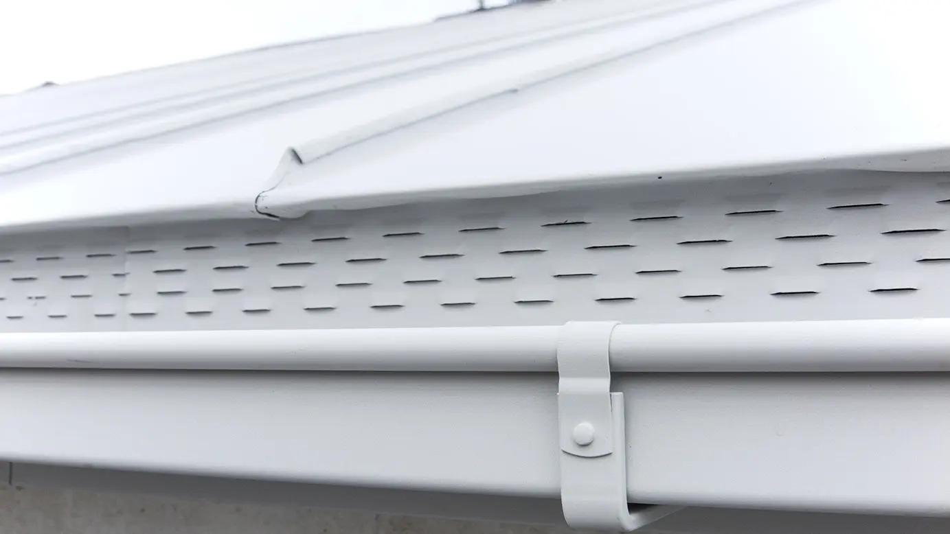 Zoom sur le système complet PREFA : la couverture en aluminium et la gouttière carrée dans la même teinte, le blanc prefa P.10