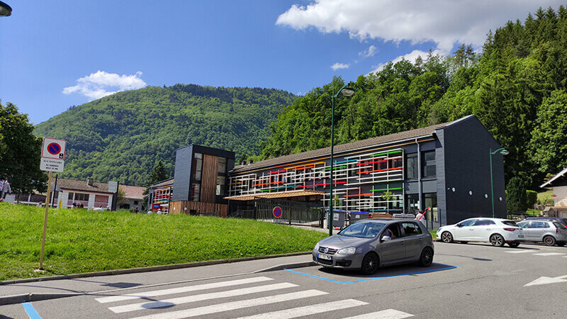 Vue depuis le parking de cette façade rénovée avec le Siding.X PREFA sous un beau soleil de printemps