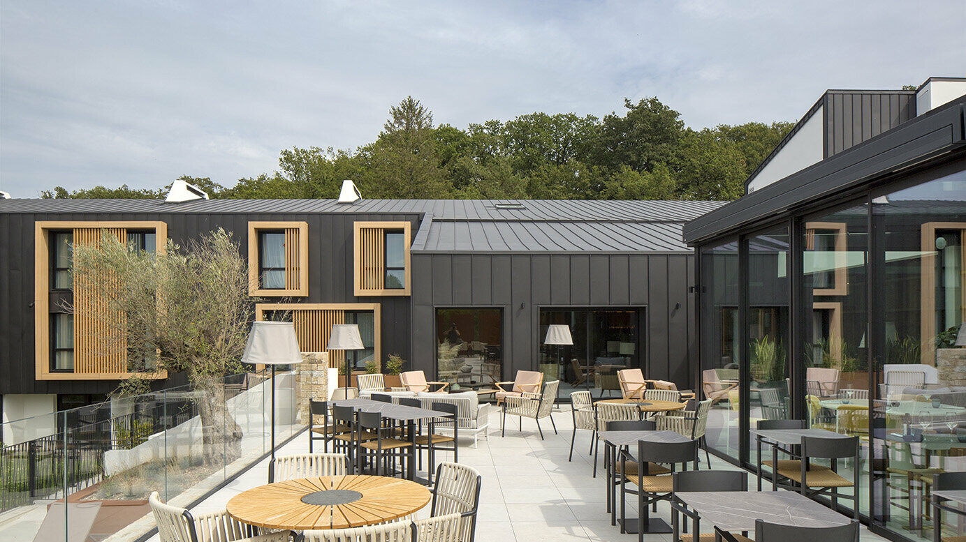 Prise de vue depuis la terrasse du restaurant de l'Hôtel Le Landreau, dont la façade a récemment été rénové en aluminium PREFA