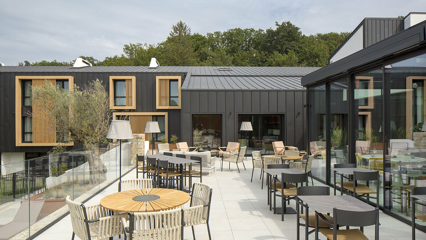 Prise de vue depuis la terrasse du restaurant de l'Hôtel Le Landreau, dont la façade a récemment été rénové en aluminium PREFA