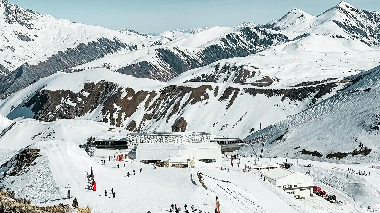 Vue éloignée d'une des stations d'altitude du nouveau téléphérique Le Jandri de la station Les 2 Alpes, recouverte de panneaux composites en aluminium PREFABOND façonné en losanges de trois couleurs différentes : blanc Prefa, blanc pur et argent fumé.