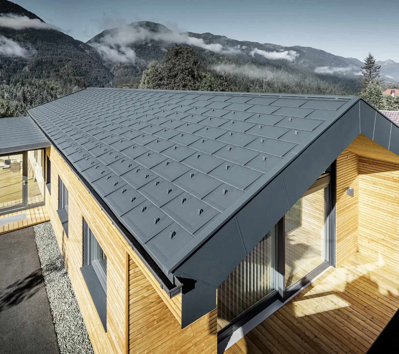 Nouvel immeuble de bureaux de Holzbau Faltheiner avec une façade en bois de mélèze, des fenêtres généreuses et une toiture PREFA en anthracite.