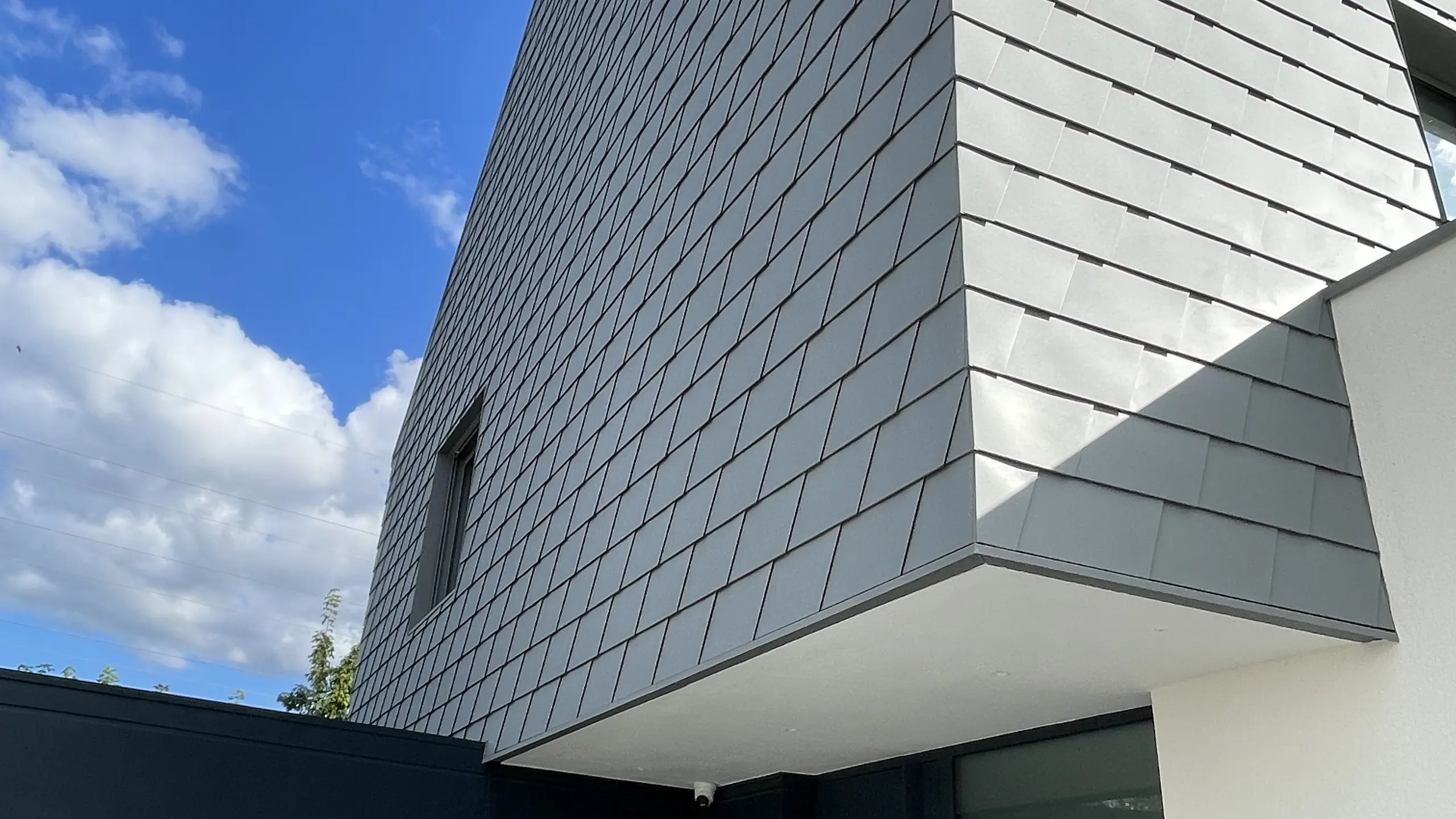 Vue de côté de cette maison contemporaine de Niederhausbergen. On voit la manière dont la toiture continue vers la façade et la netteté de l'angle et des rives.