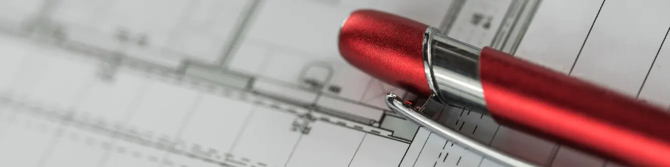 Un stylo PREFA rouge est posé sur un plan