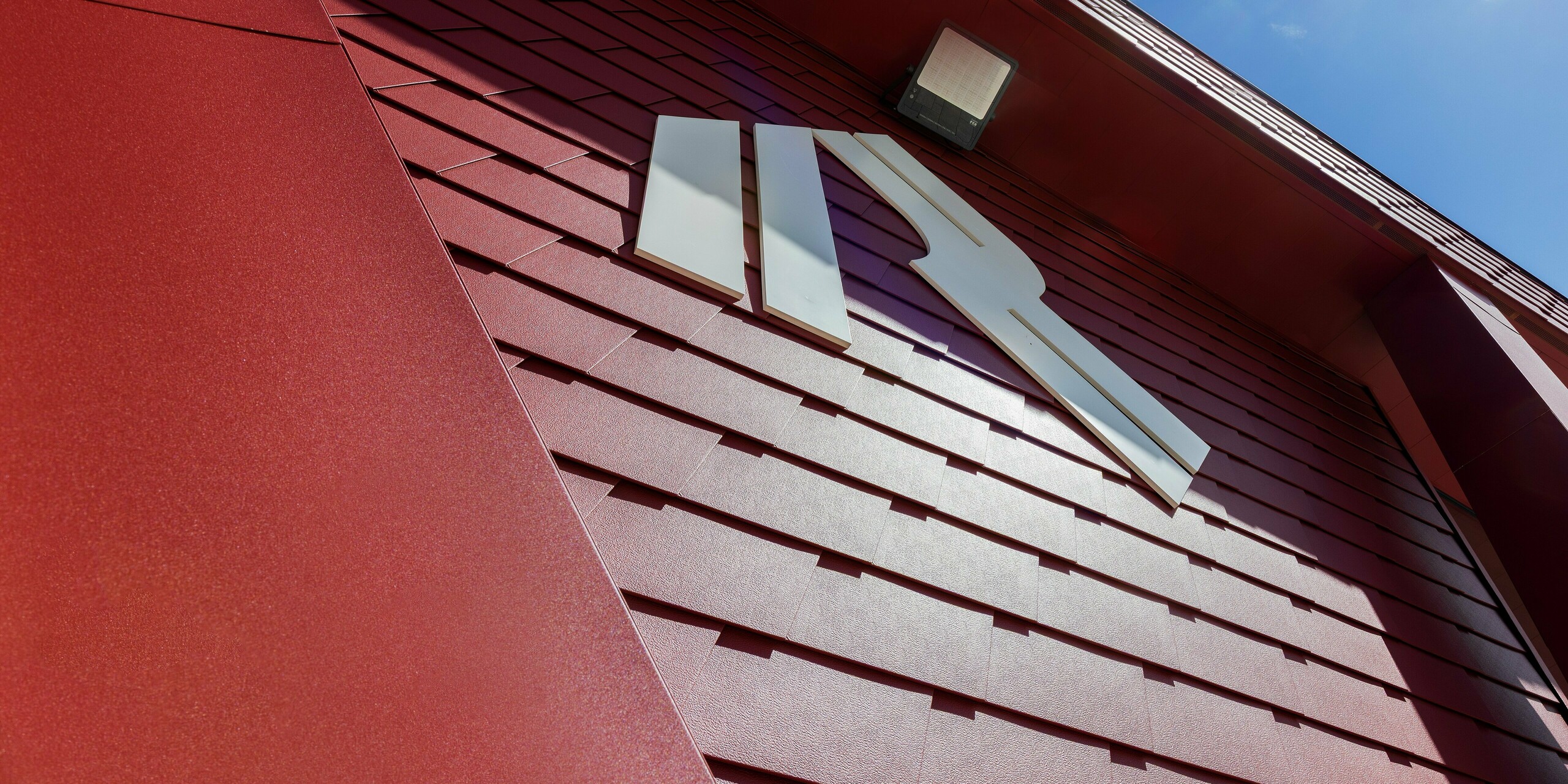 La façade remarquable du Summit Mountain Club de Ratschings arbore le design distinctif P.10 rouge oxyde, avec des bardages PREFA posés avec précision et le logo accrocheur du restaurant d'altitude, qui sert également de lieu événementiel. Le robuste revêtement en aluminium offre à la fois une esthétique soignée et une excellente protection contre les conditions climatiques extrêmes de la montagne. Son design moderne s'intègre parfaitement au paysage alpin et laisse une impression durable.