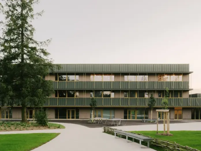 Prise de vue plus large du collège de Dole dont la façade a été entièrement rénové en aluminium PREFALZ dans une teinte spéciale verte