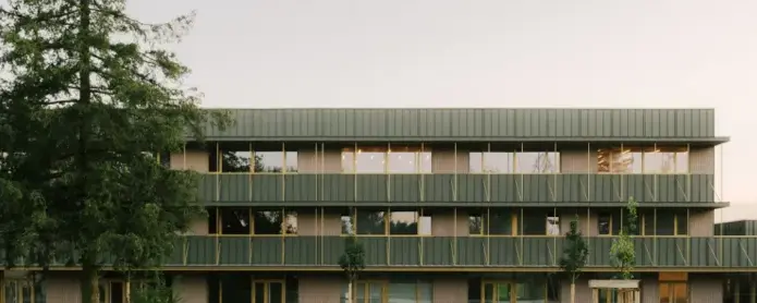 Prise de vue plus large du collège de Dole dont la façade a été entièrement rénové en aluminium PREFALZ dans une teinte spéciale verte