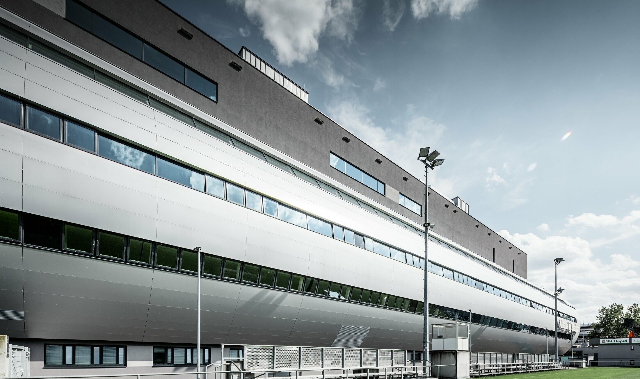 Vue de l’Allianz Stadion à Vienne depuis le terrain d’entraînement ; le tube conduisant à l’intérieur du stade est habillé avec le panneau composite en aluminium PREFA couleur argent métallisé.