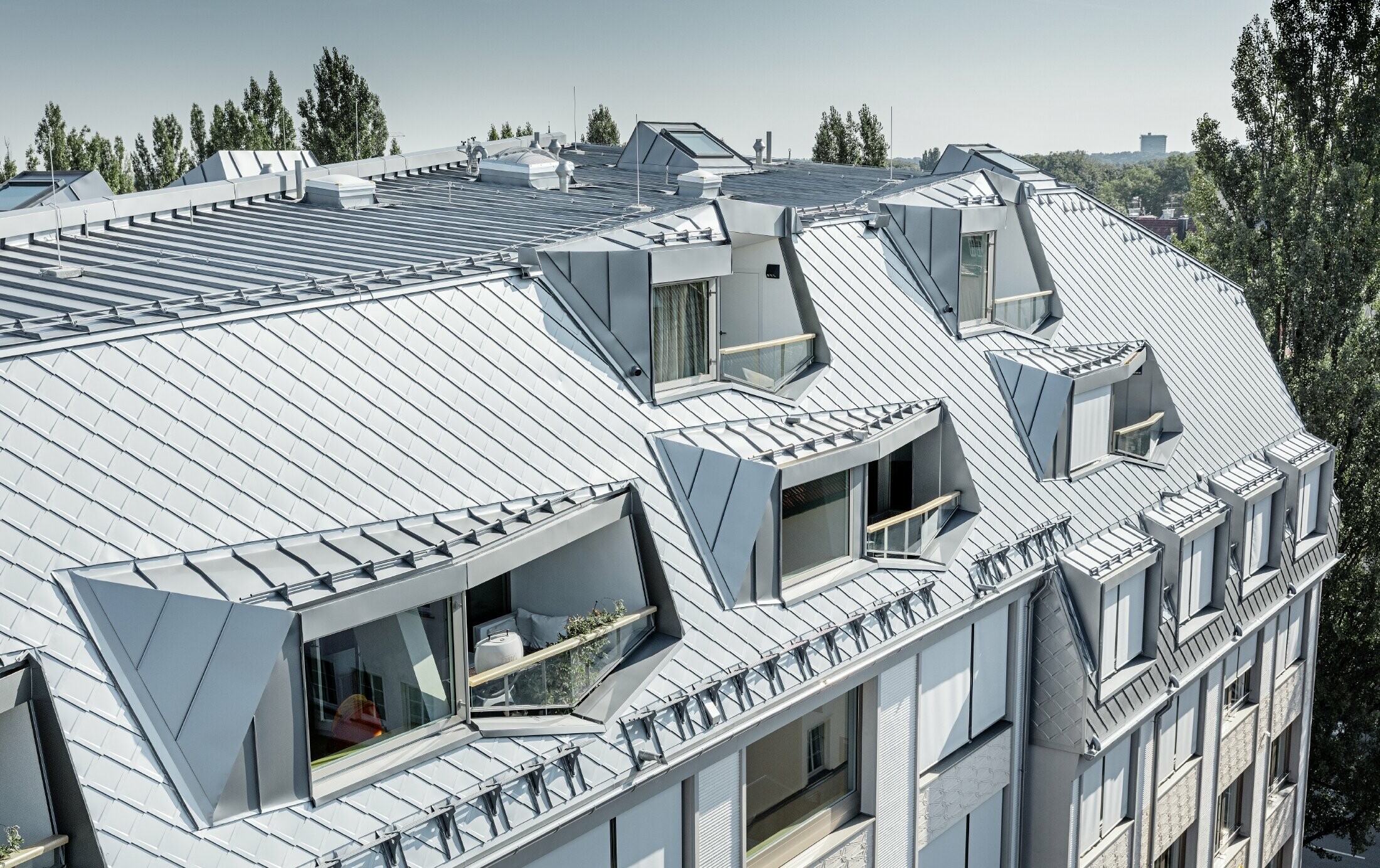 Appartements mansardés rénovés et dotés de spacieuses mezzanines, aménagés dans un immeuble d’habitation et de commerces munichois de la Leopoldstraße, à l’angle de la Hohenzollernstraße — Couverture de toit réalisée avec des losanges de toiture PREFA