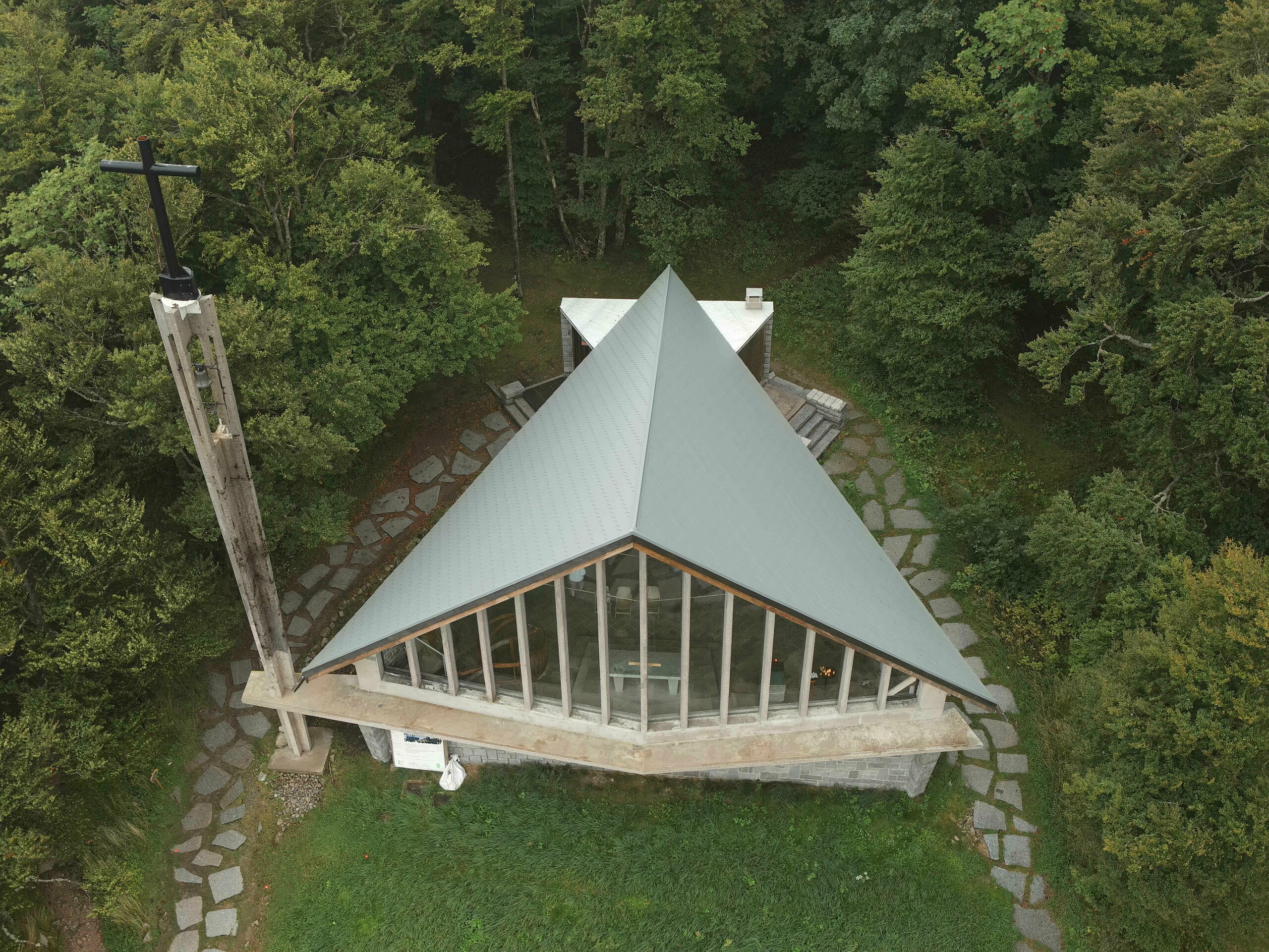 Prise de vue par drone de la toiture de la chapelle du Col de la Schlucht rénovée grâce aux bardeaux en aluminium PREFA dans la teinte P.10 gris souris. On aperçoit également les larges baies vitrées sur le devant de la chapelle.