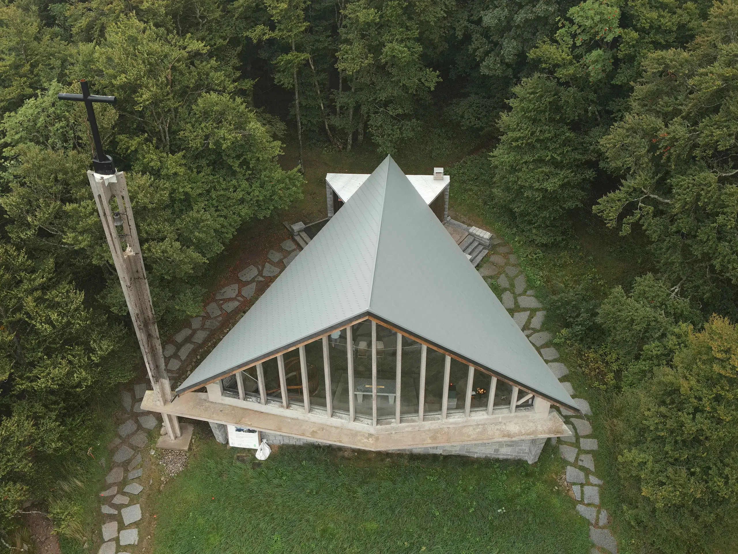 Prise de vue par drone de la toiture de la chapelle du Col de la Schlucht rénovée grâce aux bardeaux en aluminium PREFA dans la teinte P.10 gris souris. On aperçoit également les larges baies vitrées sur le devant de la chapelle.