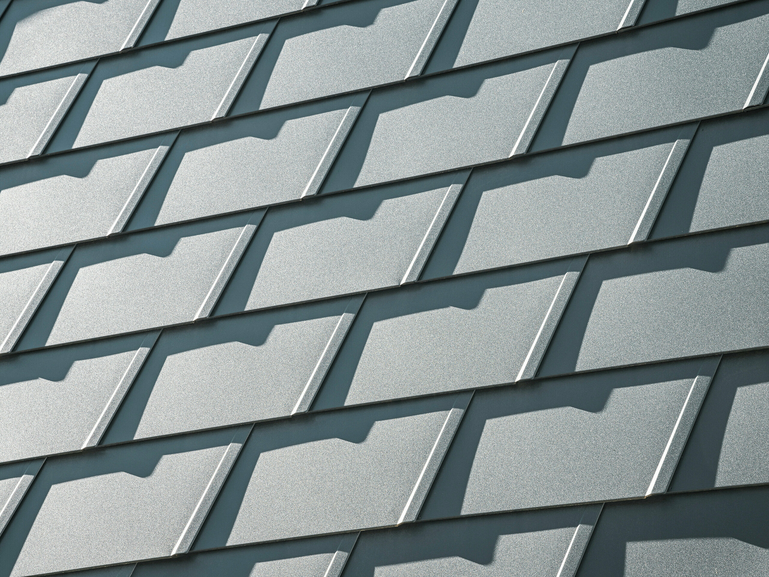 Vue détaillée des DS.19 PREFA en P.10 anthracite sur une maison individuelle à Mechernich. Les bardeaux de toiture en aluminium durables offrent une protection optimale contre les intempéries et assurent une conception de toiture moderne et esthétique.