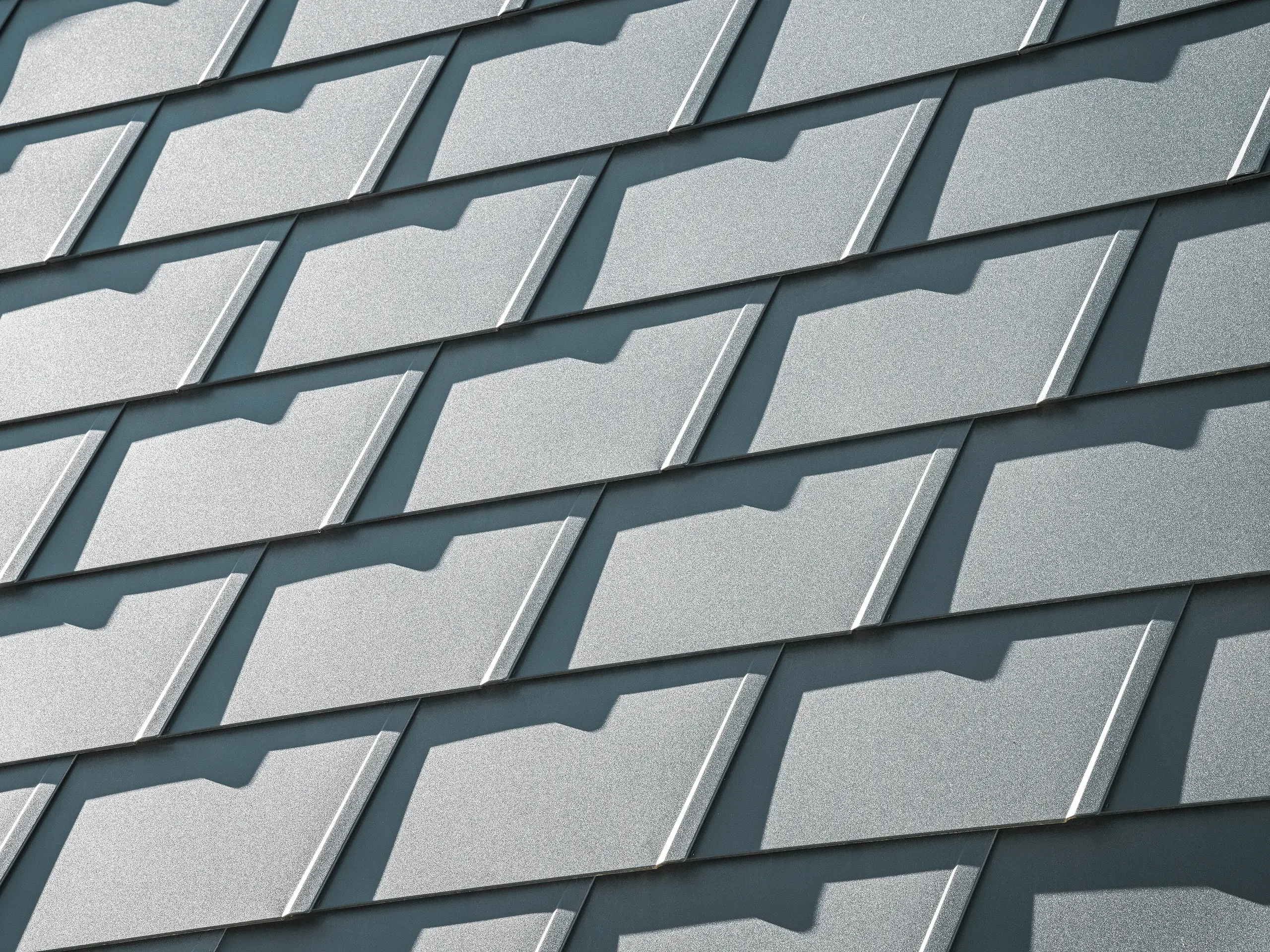 Vue détaillée des DS.19 PREFA en P.10 anthracite sur une maison individuelle à Mechernich. Les bardeaux de toiture en aluminium durables offrent une protection optimale contre les intempéries et assurent une conception de toiture moderne et esthétique.
