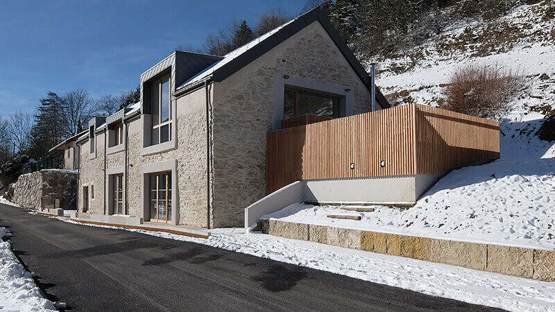 Vue entre soleil et neige de cette rénovation finalisée : le gîte l'Atmosphère a désormais une nouvelle toiture grâce aux losanges PREFA