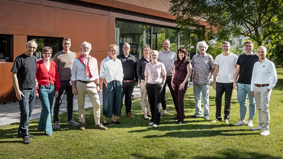 [Translate to Français:] Gruppe von Architektur-Experten vor einer modernen Winzerresidenz im Seewinkel. Das Bild wurde inszeniert vor einem markanten, rostfarben schimmernden Gebäude mit klaren Linien und großzügigen Glasflächen. Die metallische Oberfläche reflektiert das Licht und setzt einen starken, visuellen Akzent in der natürlichen Umgebung.