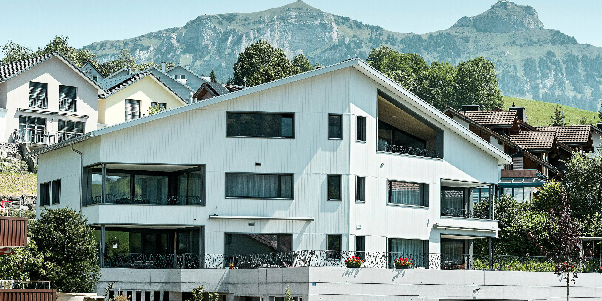 Sidings PREFA en gris pierre P.10 et blanc Prefa P.10 sur les façades de deux immeubles d'habitation voisins à Weissbad, en Suisse.