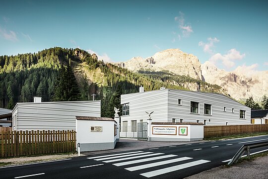 Devant un impressionnant décor montagneux, les quatre nouveaux bâtiments du centre logistique et d'entraînement « Villaggio Alpino Tempesti » allient paysage alpin et architecture moderne. Les bacs en aluminium PREFALZ posés avec précision dans la couleur P.10 blanc Prefa garantissent des lignes claires, une grande résistance et des avantages climatiques. Ils constituent une déclaration de design fonctionnel au cœur du Tyrol du Sud. Devant la route d'accès à la caserne moderne se trouve une rue avec un passage piéton.