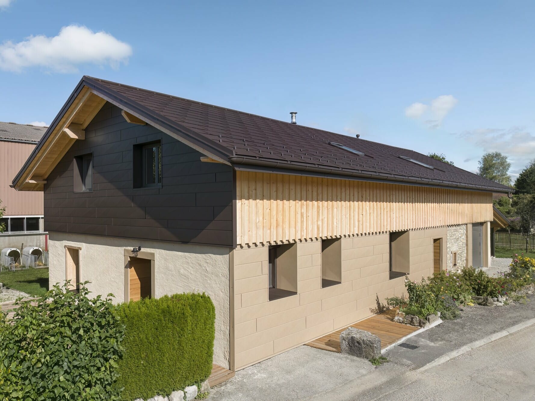 Photo d'ensemble de cette maison individuelle récemment rénovée à l'aide de plusieurs produit PREFA : le R.16 pour la couverture et le Siding.X pour la façade