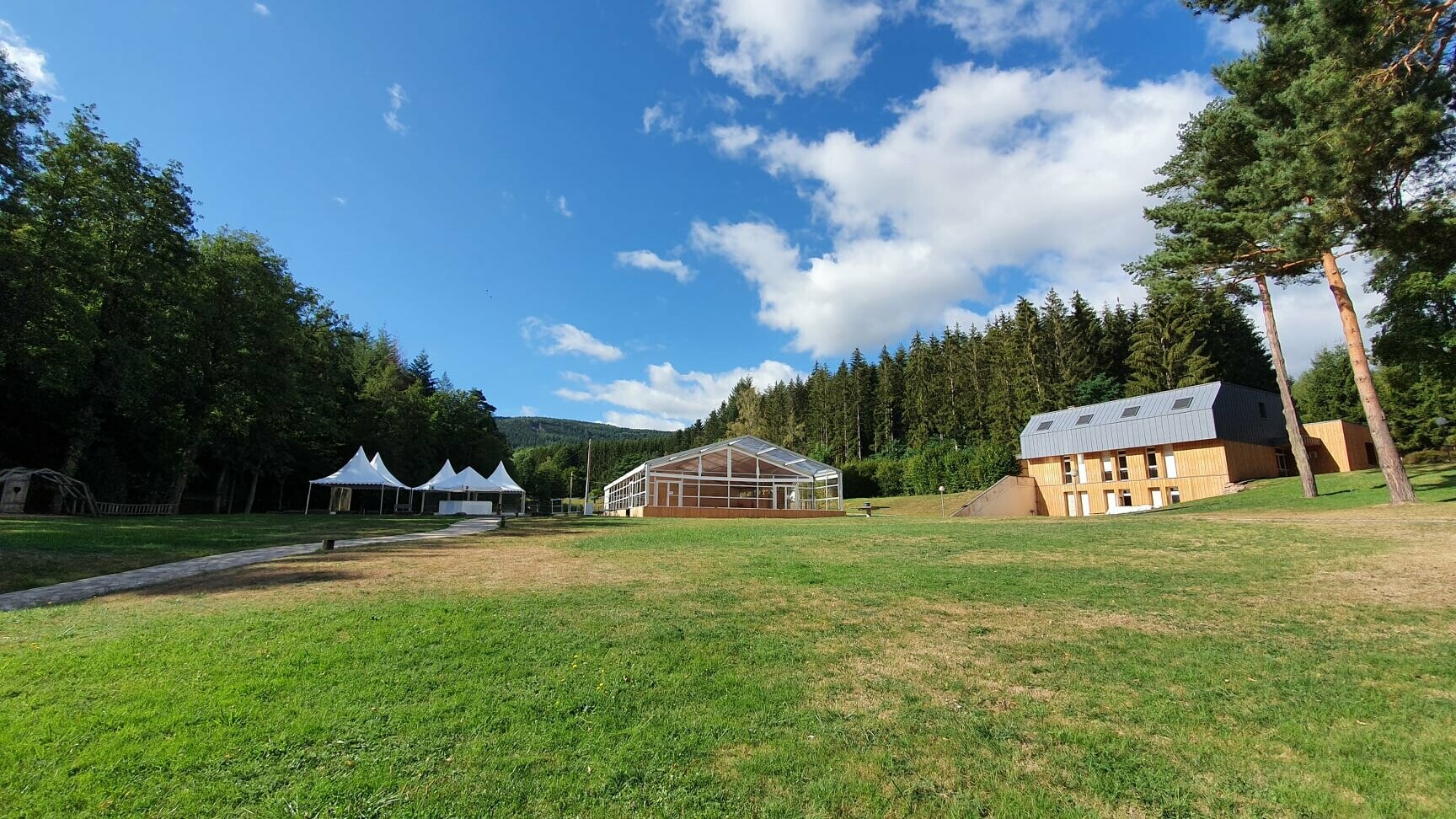 Vue éloignée de ce domaine où on aperçoit dans le fond la toiture en PREFALZ et les raccords de Velux en P.10 gris pierre