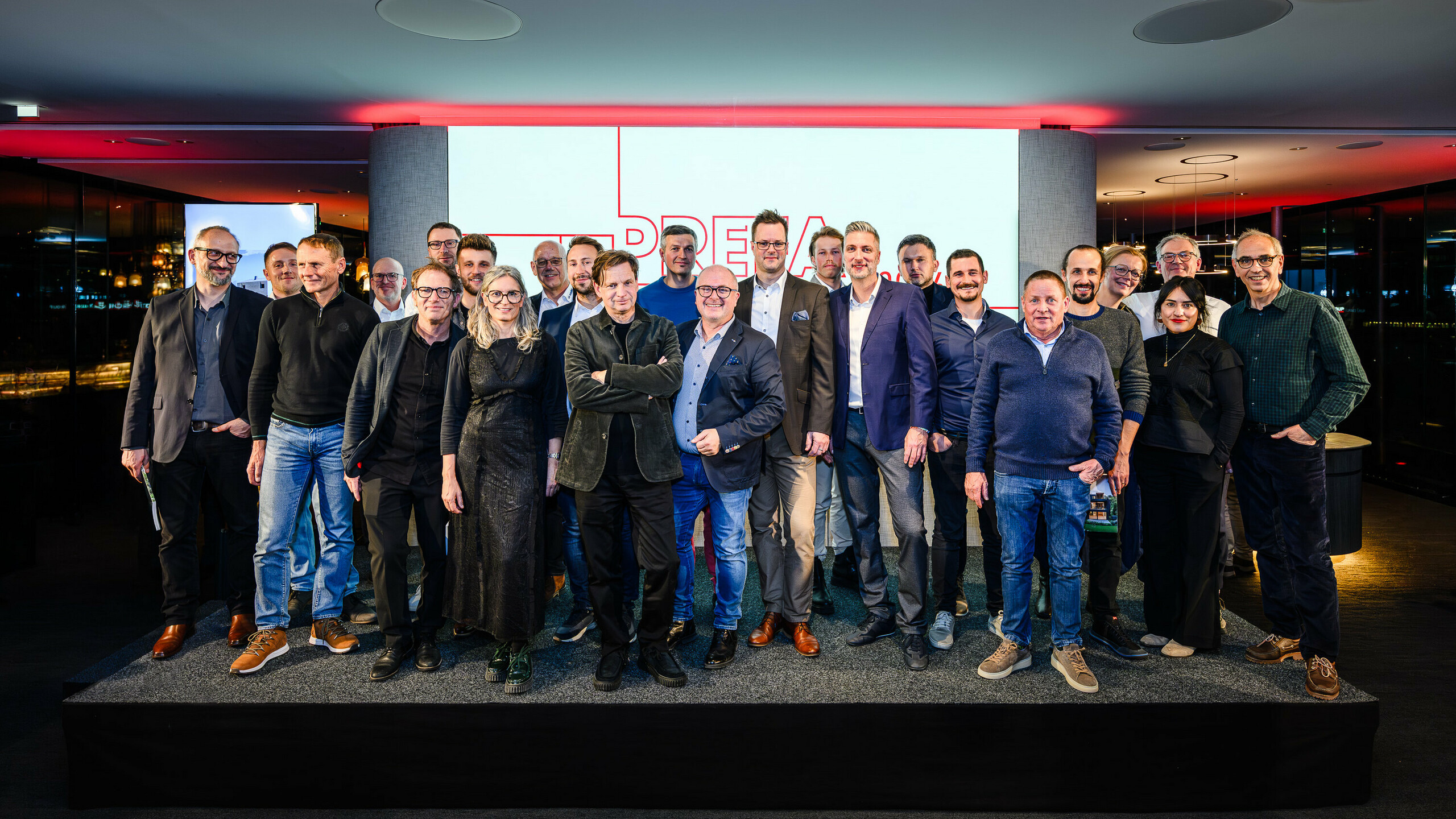 Photo de groupe des architectes, urbanistes et fabricants sur la scène de la présentation PREFARENZEN 2026 au k47.wien – un symbole fort de communauté, de créativité et d'architecture d'avenir. Devant le logo PREFARENZEN illuminé se tiennent les concepteurs des projets impressionnants intégrant l'aluminium PREFA. Cette scène reflète la fierté, l'innovation et la collaboration. Les produits PREFA offrent des solutions durables et résistantes aux intempéries, au design soigné – idéales pour les concepts architecturaux modernes. Une soirée inspirante, riche en échanges, en visions et en partenariats solides.