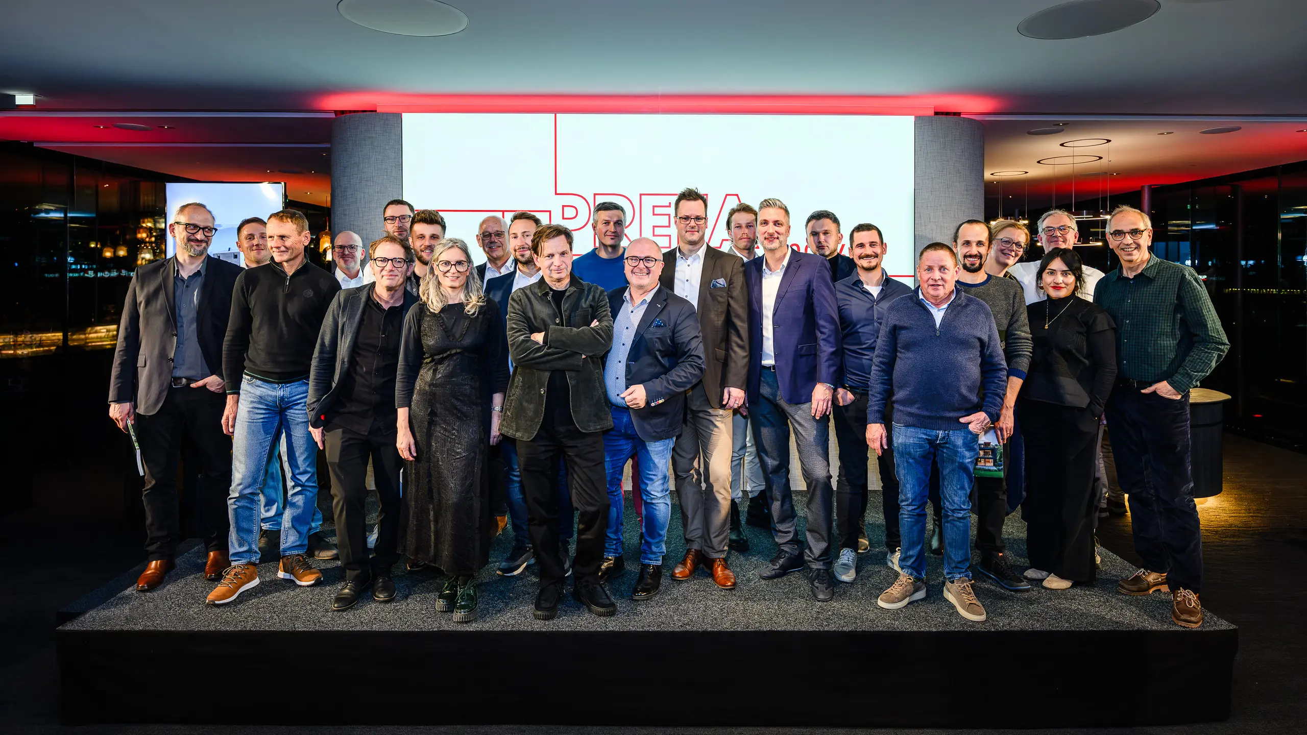 Photo de groupe des architectes, urbanistes et fabricants sur la scène de la présentation PREFARENZEN 2026 au k47.wien – un symbole fort de communauté, de créativité et d'architecture d'avenir. Devant le logo PREFARENZEN illuminé se tiennent les concepteurs des projets impressionnants intégrant l'aluminium PREFA. Cette scène reflète la fierté, l'innovation et la collaboration. Les produits PREFA offrent des solutions durables et résistantes aux intempéries, au design soigné – idéales pour les concepts architecturaux modernes. Une soirée inspirante, riche en échanges, en visions et en partenariats solides.