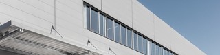Prise de vue d'un bâtiment recouvert de Sidings PREFA dans les nouvelles largeurs. Les largeurs plus grandes présentent de nombreux avantages pour l'esthétisme de votre façade. 
