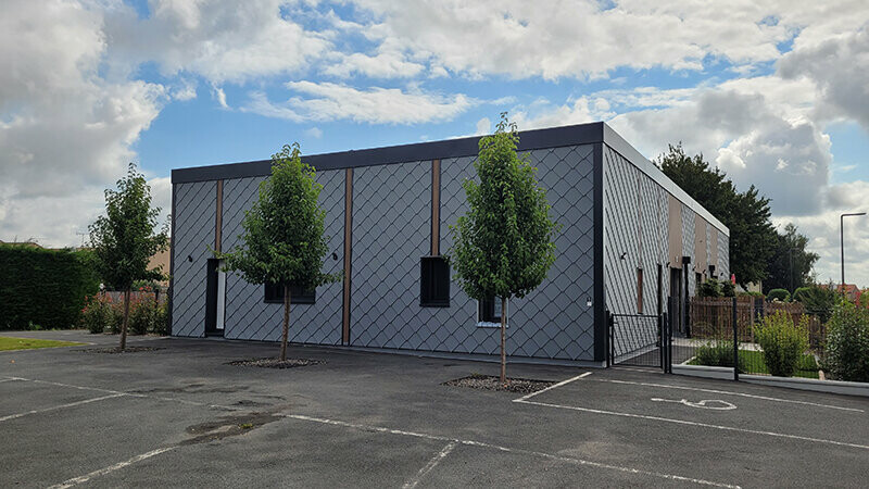 Vue sous un ciel nuageux de cette maison de retraite récemment rénovée avec les produits de façade Siding et losange PREFA