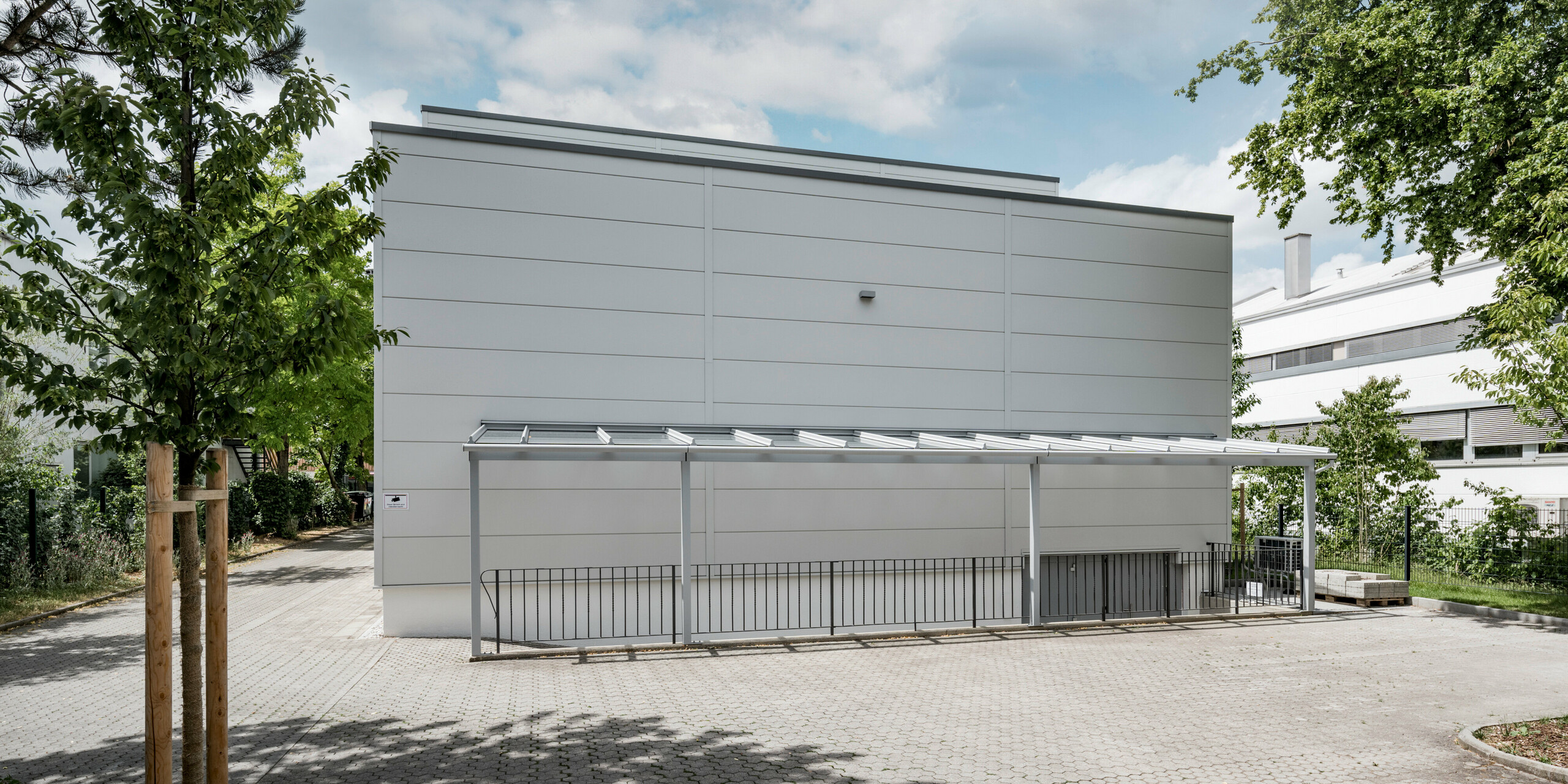 Des Sidings PREFA grand format entourent un bâtiment d'entreprise à Oberschleißheim (Allemagne). Les éléments de façade extra-larges en aluminium ont été choisis dans la couleur blanc Prefa.