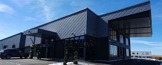 Nouvelle chocolaterie Marc Verdant à Pontarlier dont la façade a été réalisée en Siding, Siding.X et losanges 44x44 dans les teintes gris pierre, argent métallisé et noir 