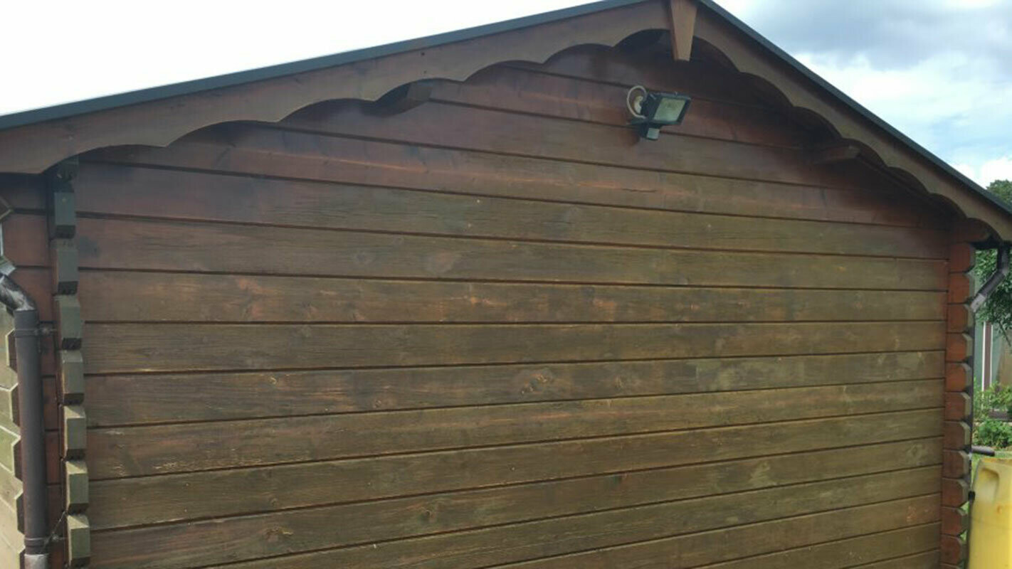 Abri de jardin avant rénovation, habillage bois abîmé par le temps, qui sera par la suite recouvert avec des Sidings PREFA imitation bois