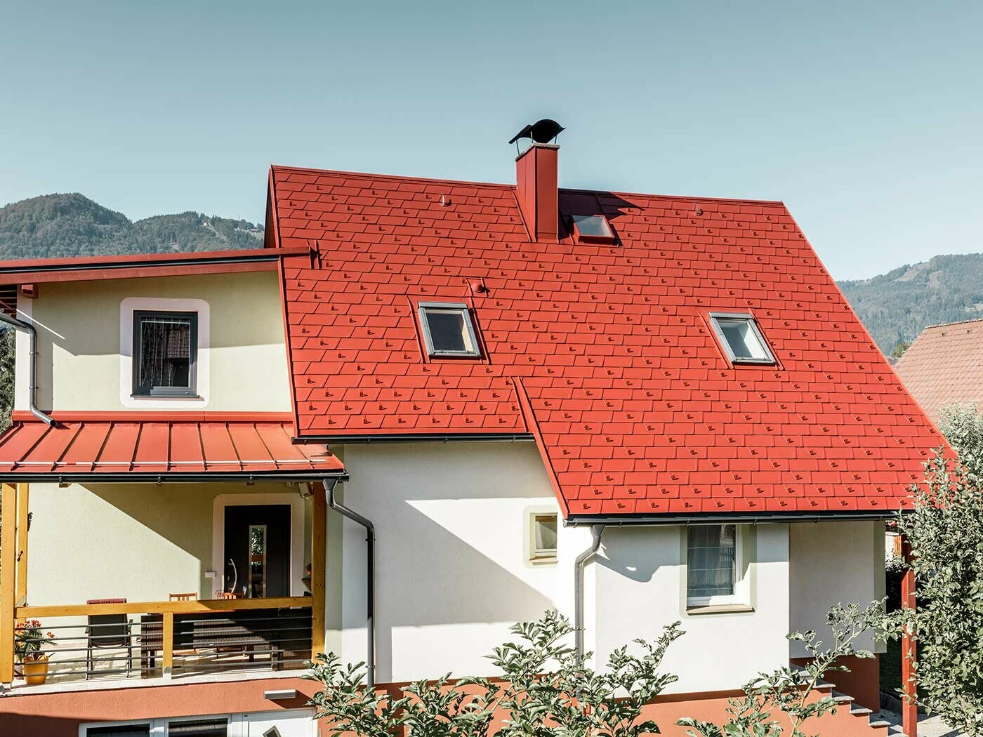 Maison individuelle classique recouverte du nouveau bardeau de toiture PREFA DS.19 en P.10 oxyde rouge.