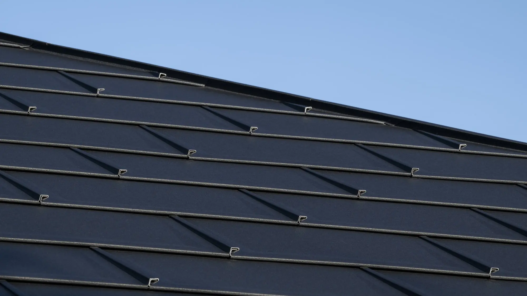 Zoom sur les R.16 en aluminium PREFA choisis pour la rénovation de cette toiture, dans la teinte P.10 noir