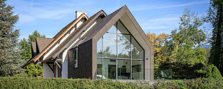 Vue de face éloignée de cette extension qui s'imbrique dans la maison individuelle grâce aux panneaux de toiture et de façade FX.12 PREFA.