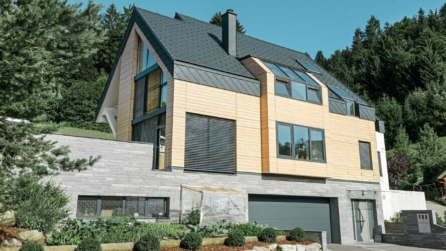 Nouvelle construction avec façade en bois clair et toiture en losanges de toiture PREFA couleur P.10 anthracite