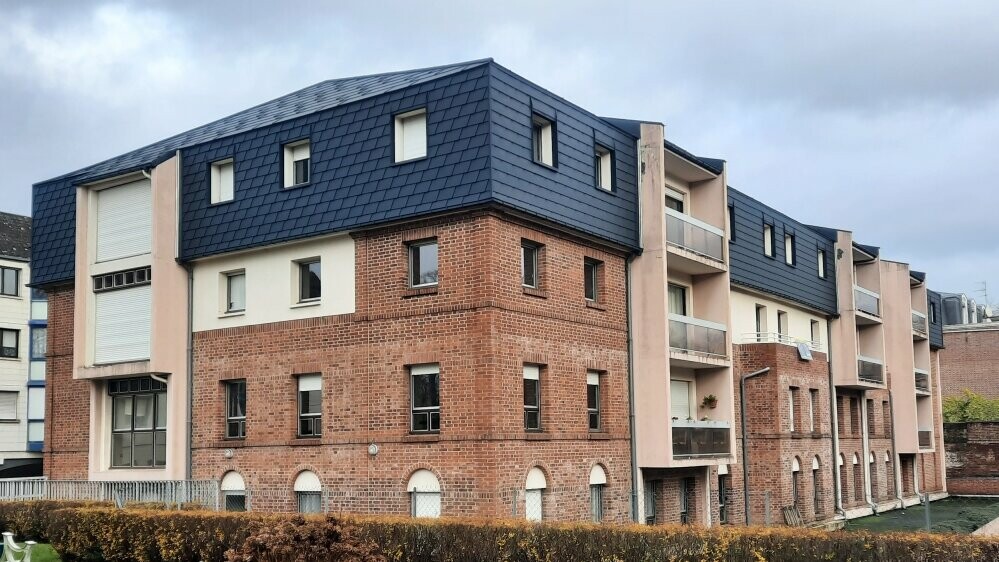 Vue d'ensemble de cette résidence située à Arras dont la toiture a été rénovée en FX.12 et bardeaux PREFA dans la teinte P.10 anthracite