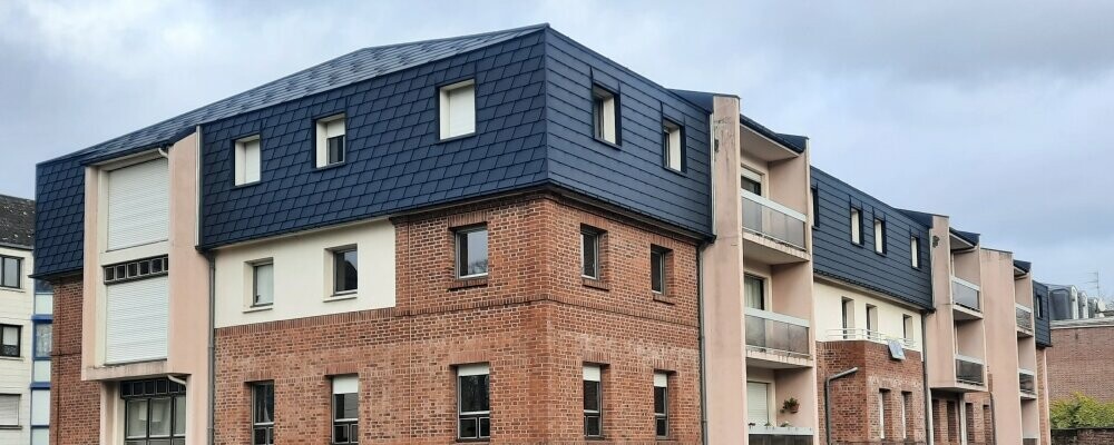 Vue d'ensemble de cette résidence située à Arras dont la toiture a été rénovée en FX.12 et bardeaux PREFA dans la teinte P.10 anthracite