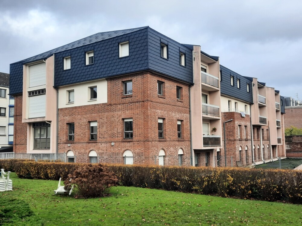 Vue d'ensemble de cette résidence située à Arras dont la toiture a été rénovée en FX.12 et bardeaux PREFA dans la teinte P.10 anthracite