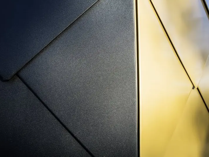 Zoom sur les produits utilisés. Le bâtiment est revêtu de losanges 44x44 PREFA dans les teintes maya gold et noir P.10