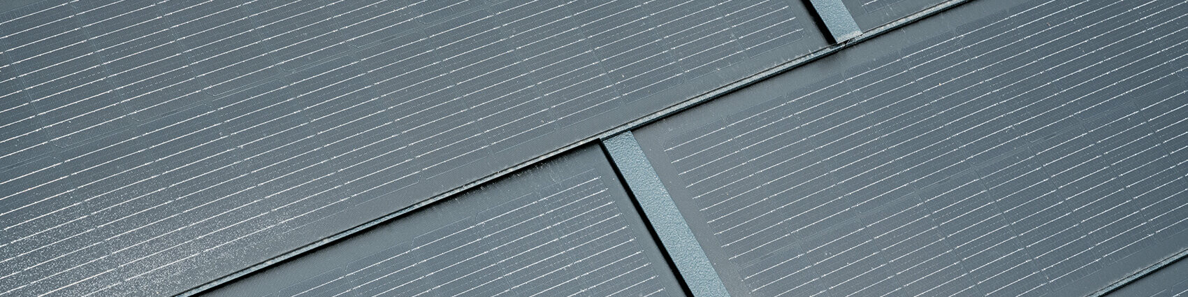 Gros plan de la tuile solaire petit format posée. La tuile solaire petit format couleur P.10 anthracite a été combinée au R.16. 