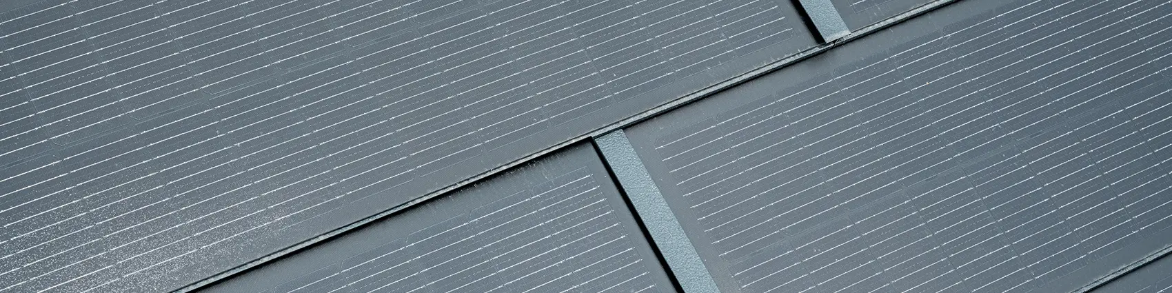 Gros plan de la tuile solaire petit format posée. La tuile solaire petit format couleur P.10 anthracite a été combinée au R.16. 
