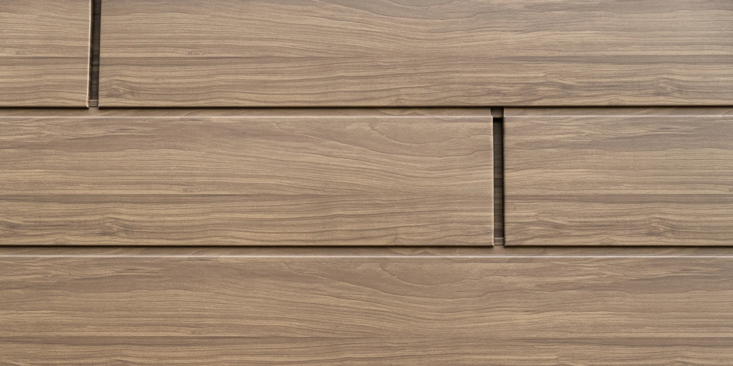 Vue détaillée des Sidings PREFA noyer foncé avec aspect bois authentique. Les panneaux de façade en aluminium durables combinent une esthétique naturelle avec une résistance aux intempéries et sans entretien.