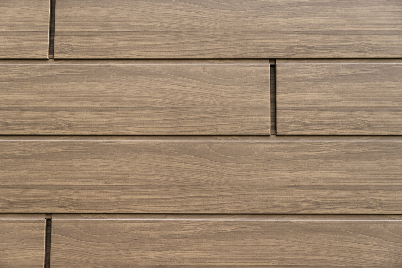 Vue détaillée des Sidings PREFA noyer foncé avec aspect bois authentique. Les panneaux de façade en aluminium durables combinent une esthétique naturelle avec une résistance aux intempéries et sans entretien.