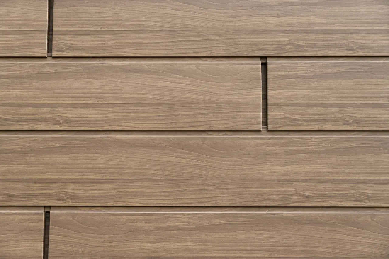 Vue détaillée des Sidings PREFA noyer foncé avec aspect bois authentique. Les panneaux de façade en aluminium durables combinent une esthétique naturelle avec une résistance aux intempéries et sans entretien.