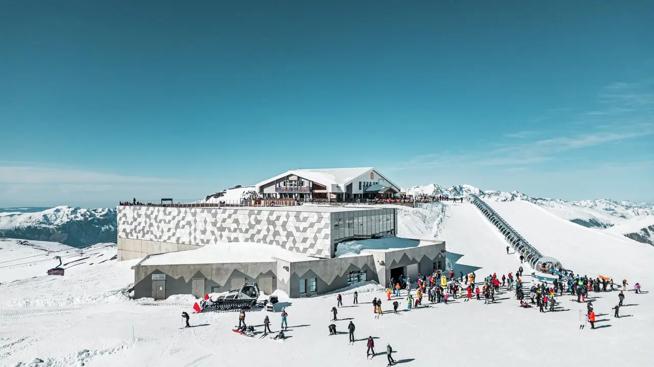 Vue éloignée d'une des stations d'altitude du nouveau téléphérique Le Jandri de la station Les 2 Alpes, recouverte de panneaux composites en aluminium PREFABOND façonné en losanges de trois couleurs différentes : blanc Prefa, blanc pur et argent fumé.
