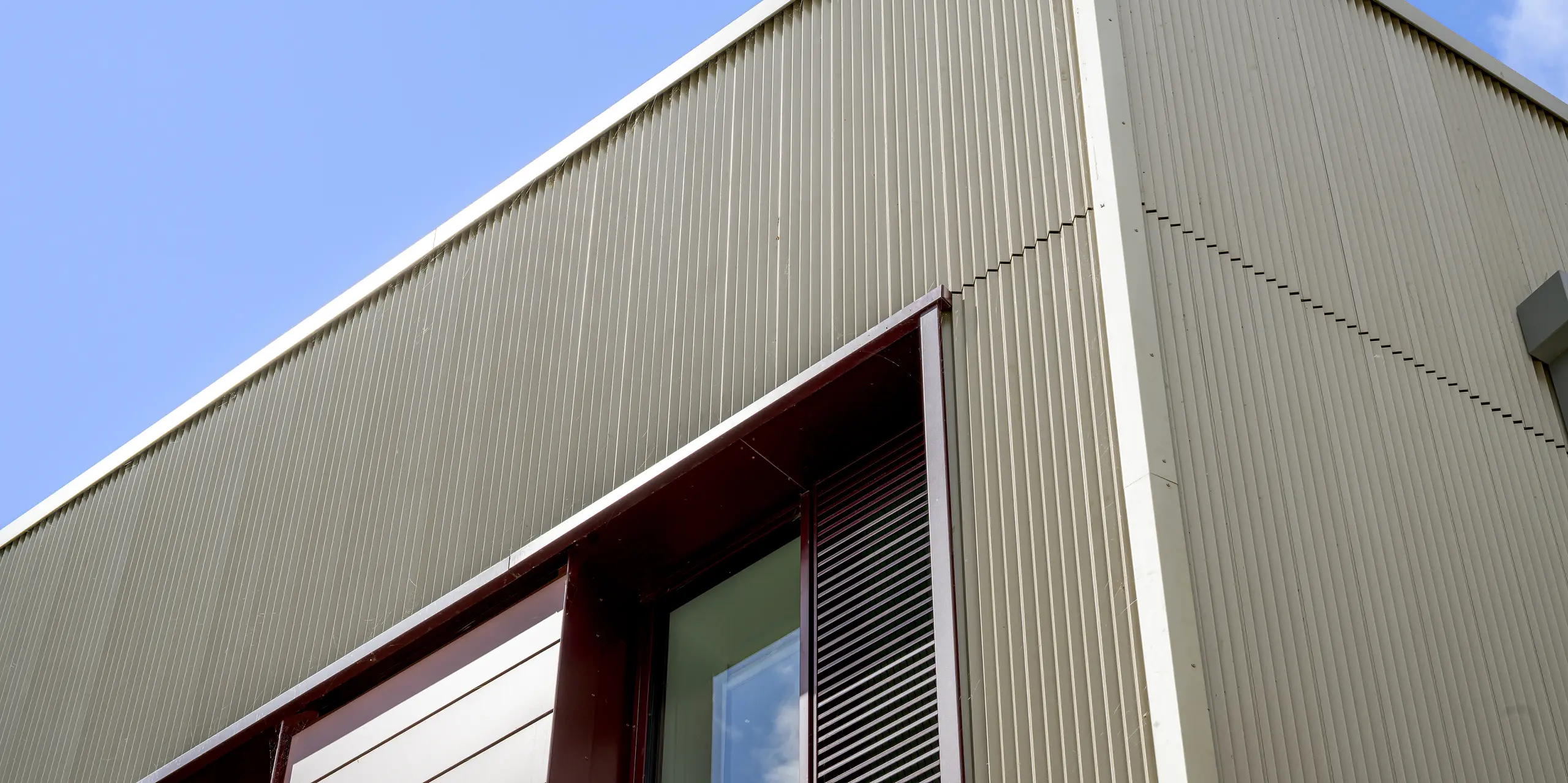 Le gros plan du lycée Currie Community High School d'Édimbourg met en valeur la façade PREFA et son profil extrudé triangle. La délicate structure verticale en aluminium P.10 bronze Prefa crée un jeu d'ombre et de lumière captivant et souligne la pureté des lignes du bâtiment. L'aluminium PREFA de haute qualité impressionne par sa durabilité, sa résistance à la corrosion et son design de façade élégant et nécessitant peu d'entretien.