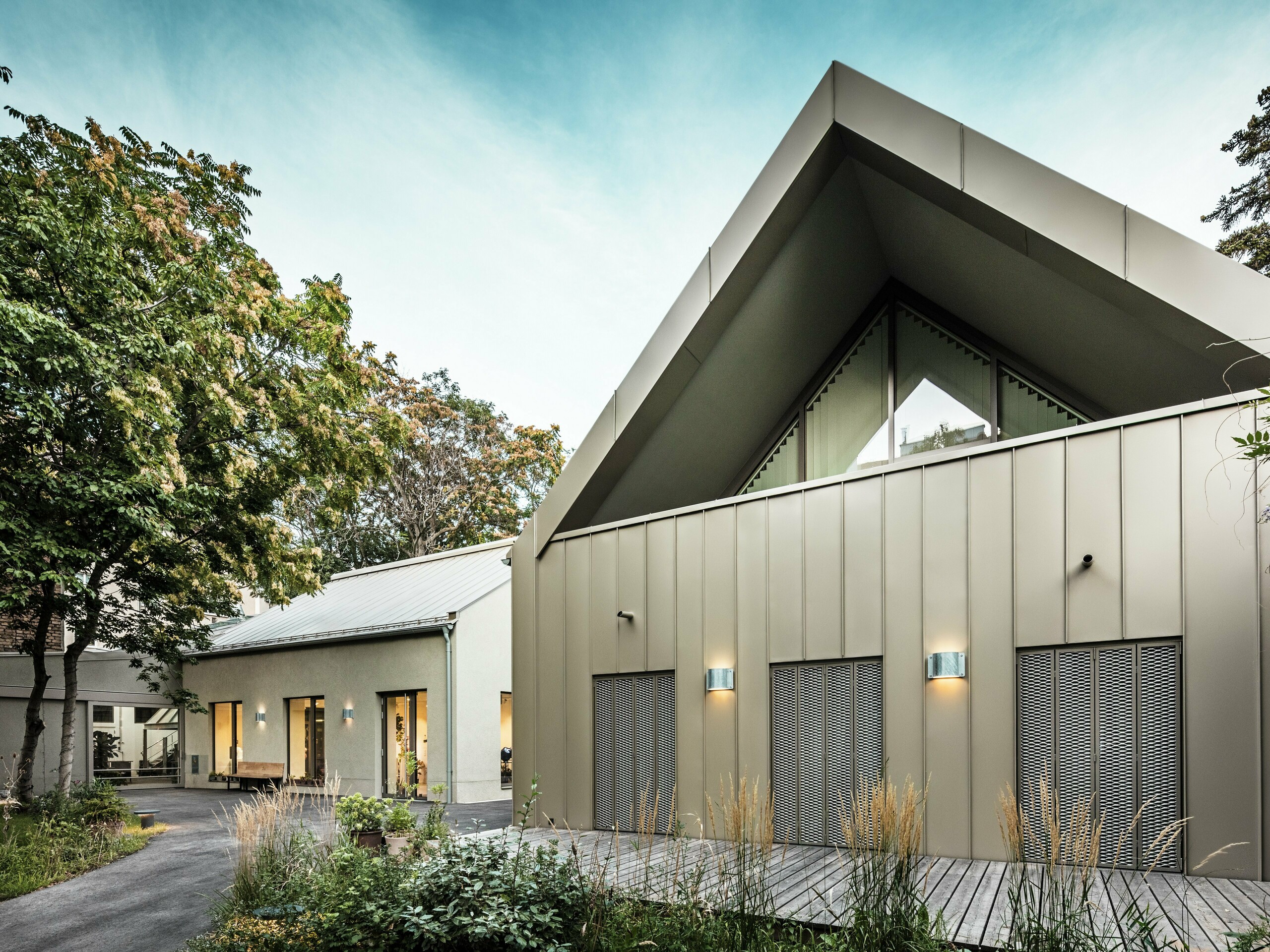 Vue de face du Studio Comploj à Vienne avec une façade en aluminium PREFALZ en P.10 bronze Prefa. L'atelier de soufflage de verre moderne allie artisanat et architecture contemporaine.