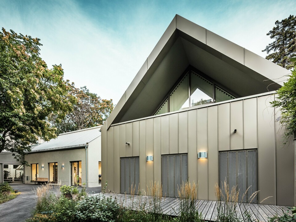 Vue de face du Studio Comploj à Vienne avec une façade en aluminium PREFALZ en P.10 bronze Prefa. L'atelier de soufflage de verre moderne allie artisanat et architecture contemporaine.