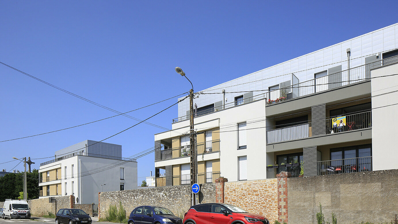 Vue éloignée de l'ensemble coeur village où les Siding Prefa ont été utilisés dans la teinte argent métallisé